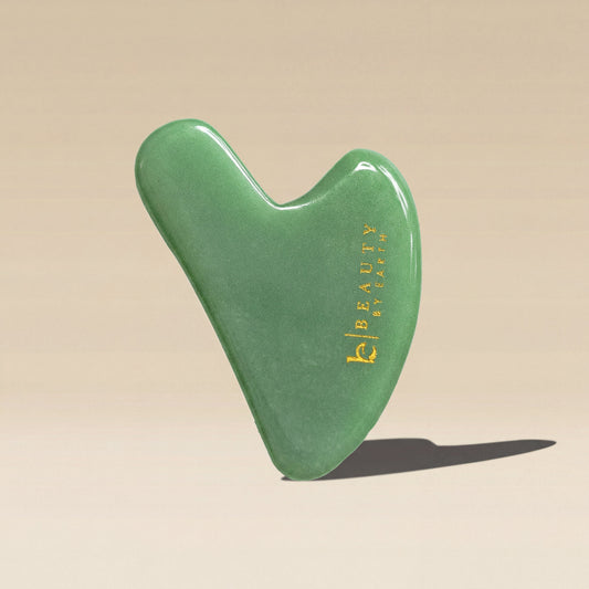 Green jade gua sha tool with 'Beauty by Earth'