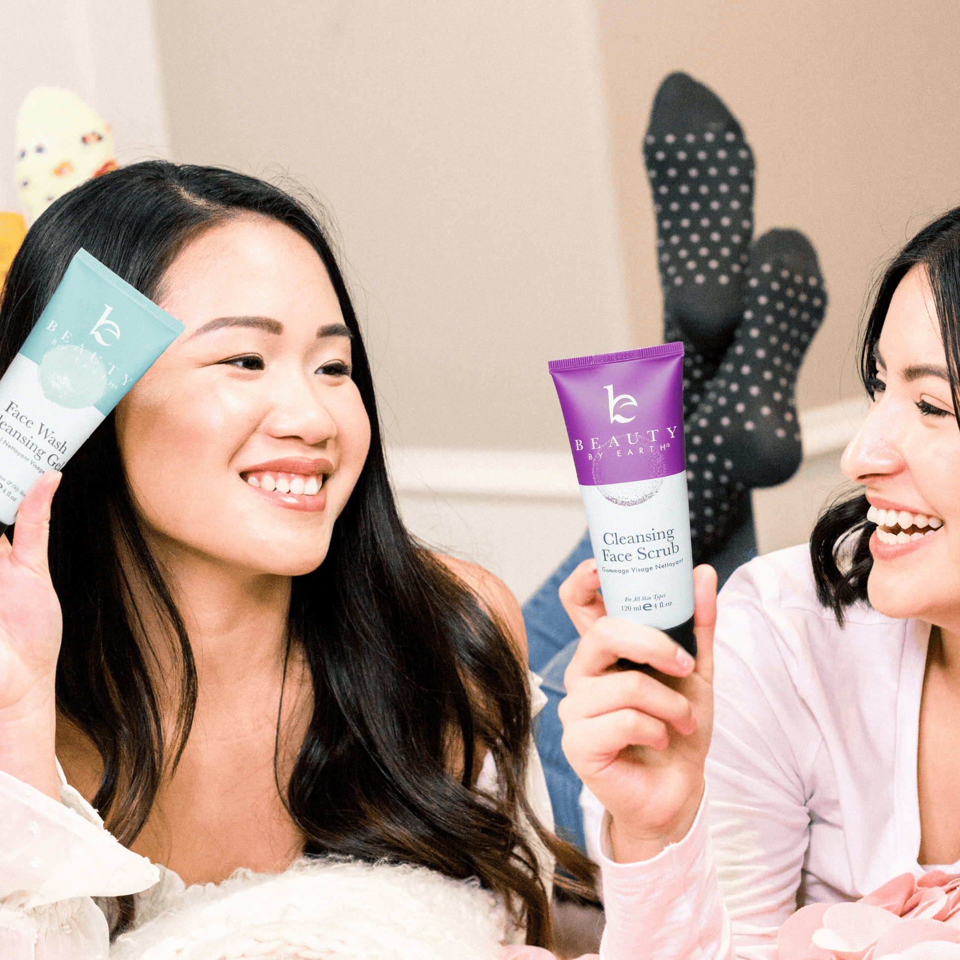Two women holding skincare products in a casual setting