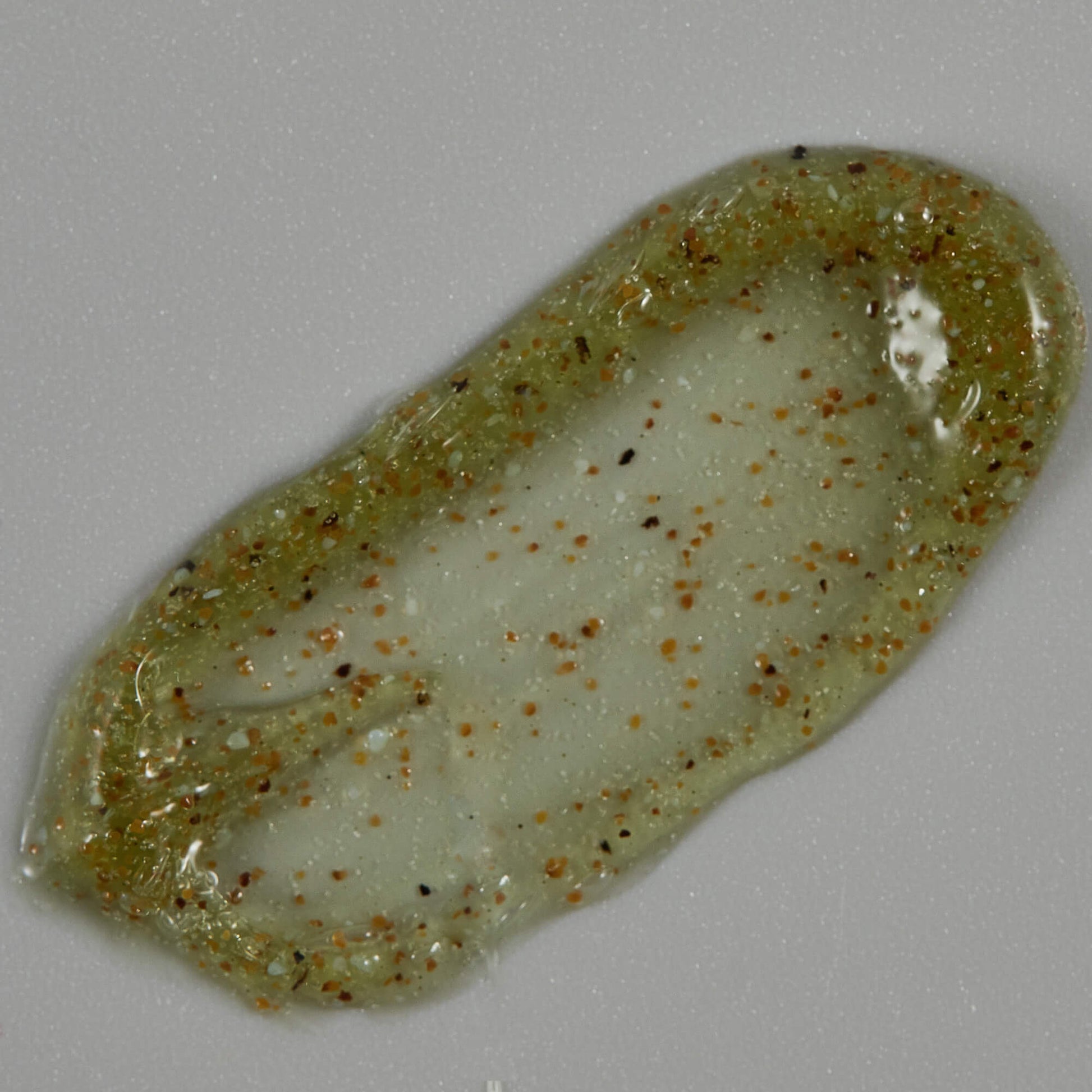 Translucent green stone with brown specks on a gray background