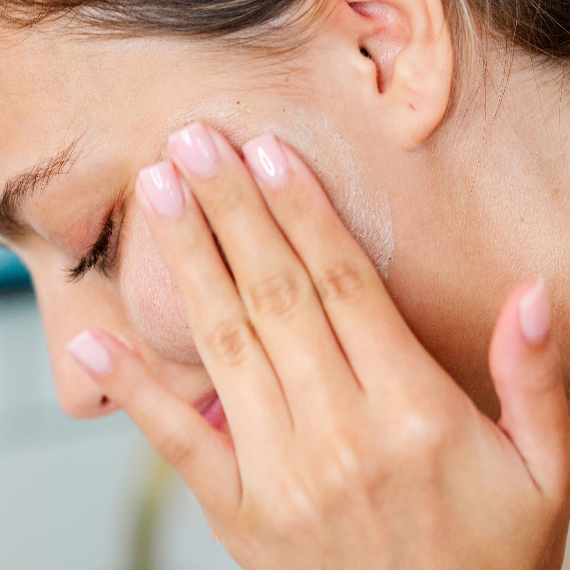Close-up of a woman's face with hand on cheek