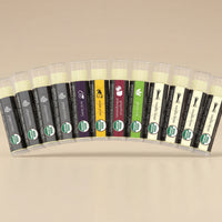 Row of lip balm tubes with various flavors on a light gray background