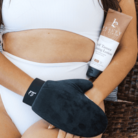 Model holding self tanner tanning lotion medium to dark and body applicator mitt on hand