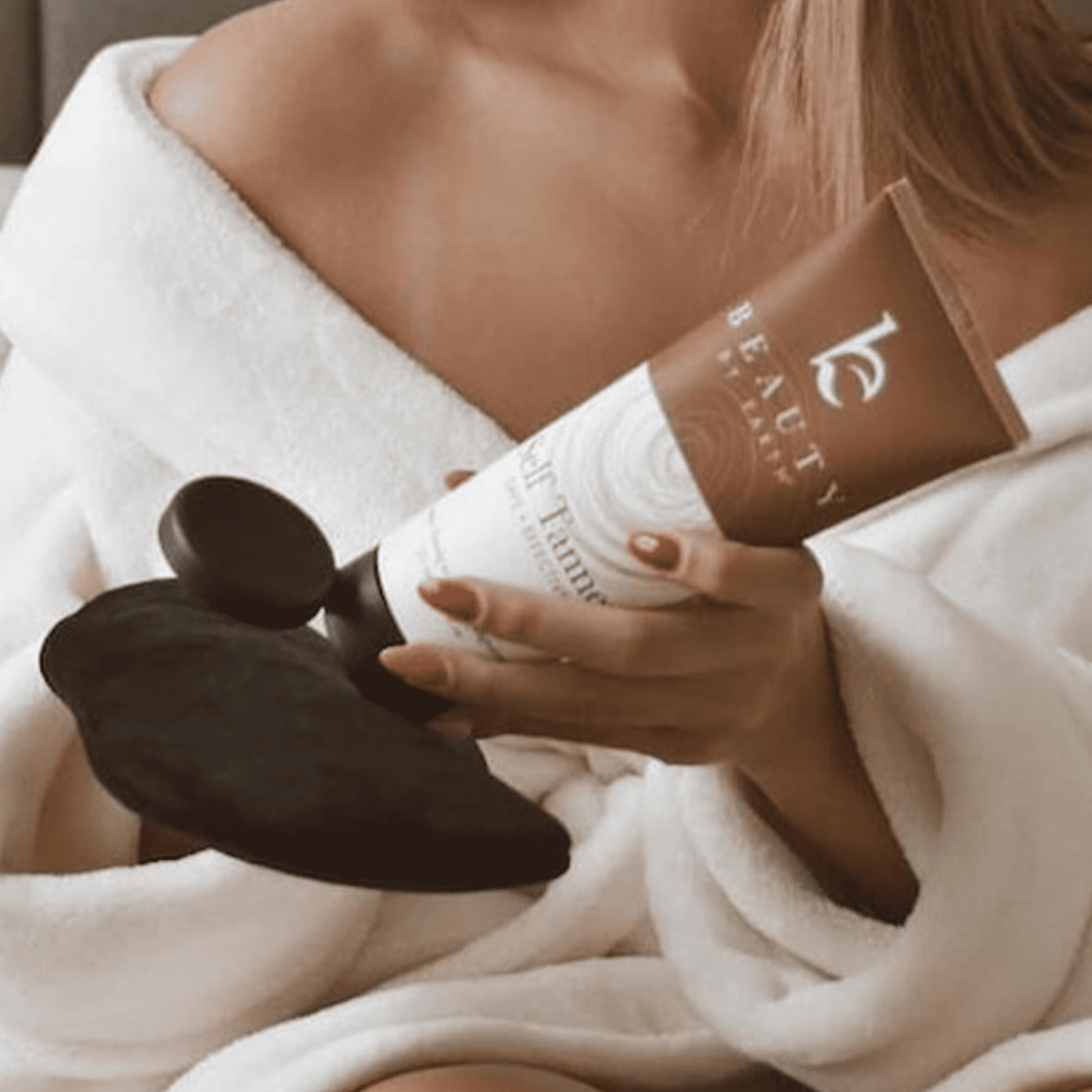 a model holding self tanner tanning lotion in hand and putting it on black applicator mitt