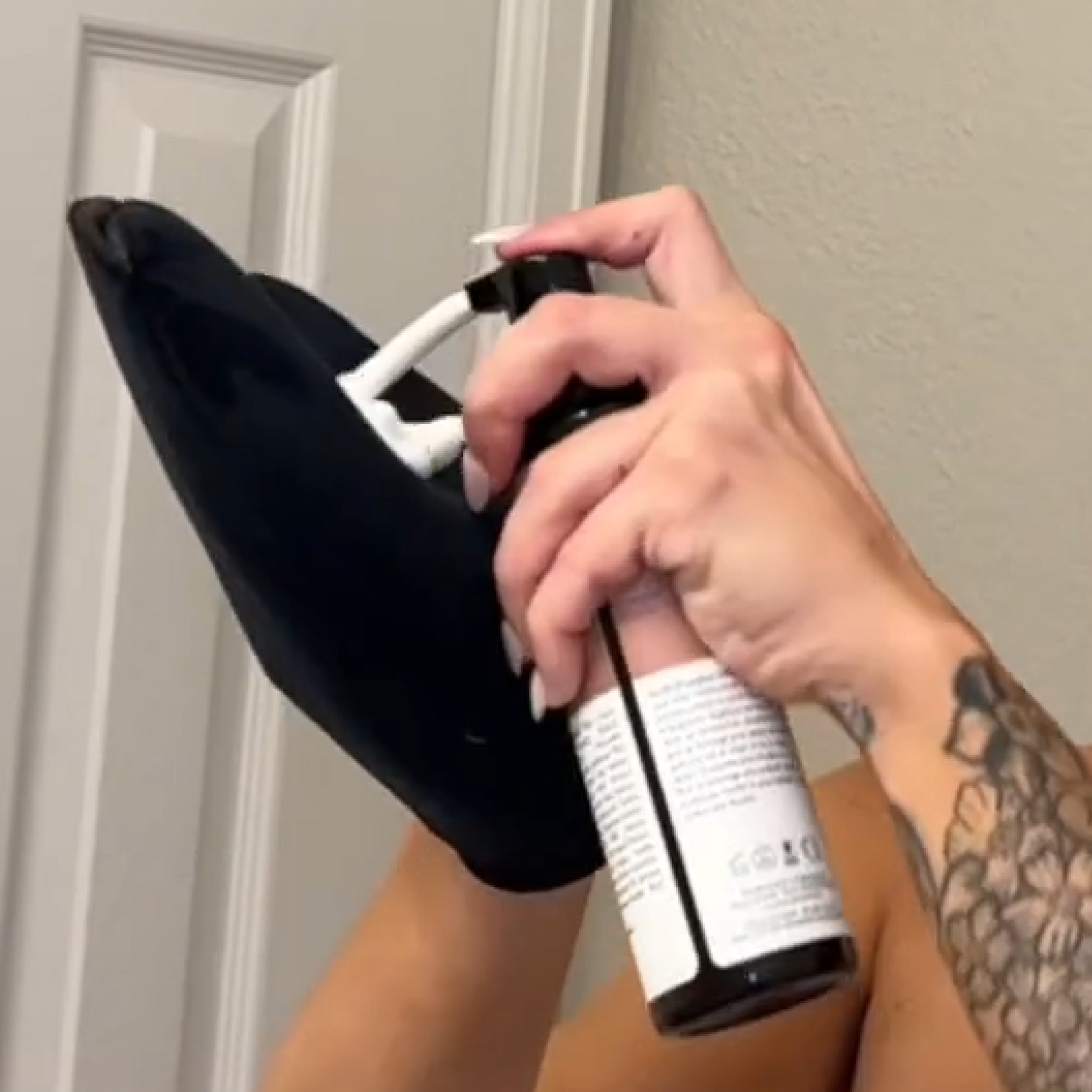 A person applying white foam from self tanning mousse onto a black applicator - demo application.