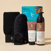 Beauty by Earth self tanning mousse and face lotion fair to medium bundle with application kit black body and face mitt, and exfoliation glove on a beige background.