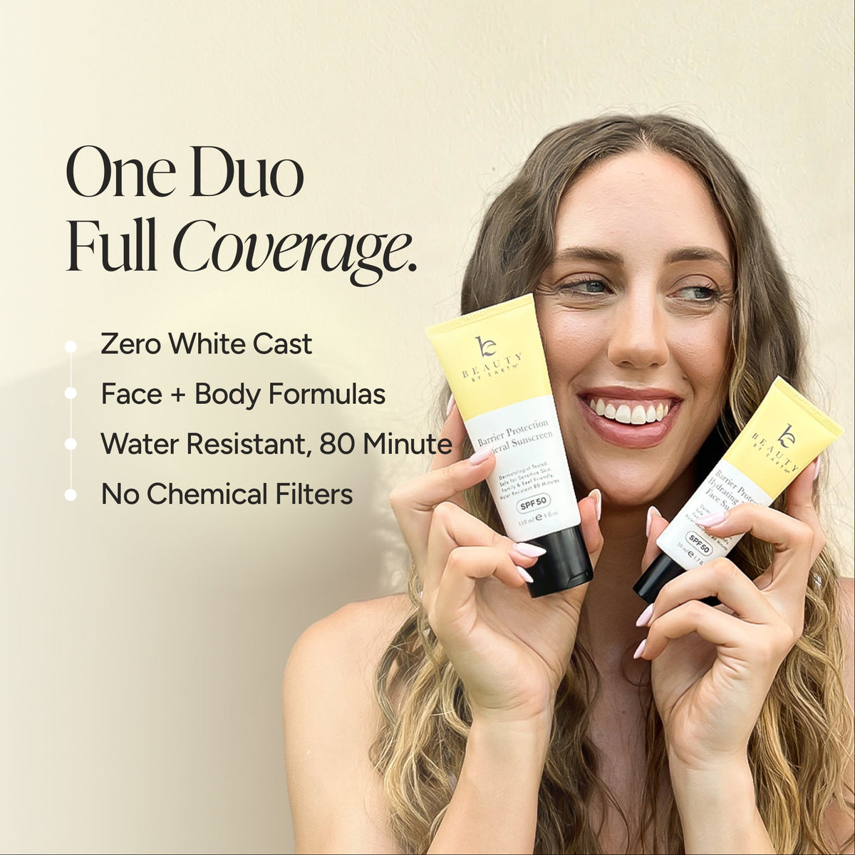 A smiling woman holds two tubes of sunscreen, one for face and one for body, against a warm beige background with promotional text reading 'One Duo Full Coverage.