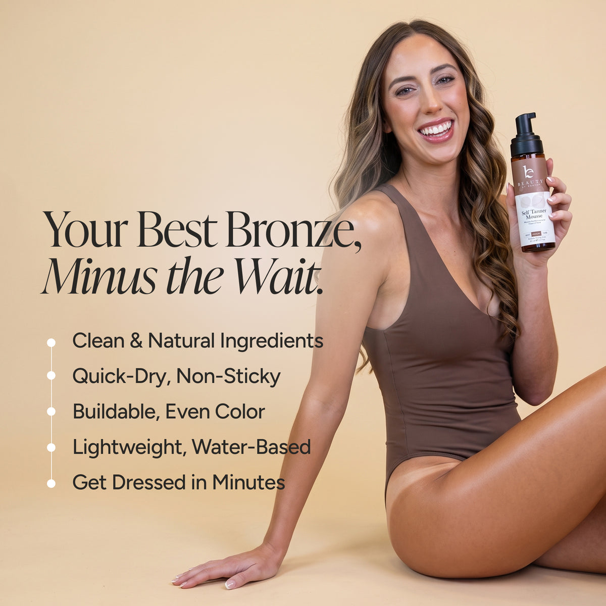 A woman in a brown bodysuit sits on a beige studio background holding a bottle self tanner mousse. Large text on the left reads, 'Your Best Bronze, Minus the Wait.