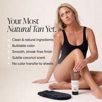 A woman in a black tank top sits on a light beige studio floor next to a bottle of Beauty By Earth Tanning Lotion. Text on the left reads 'Your Most Natural Tan Yet.