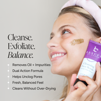 A woman in profile applies a brown scrub to her cheek while holding a purple and white Beauty by Earth Cleansing Face Scrub.