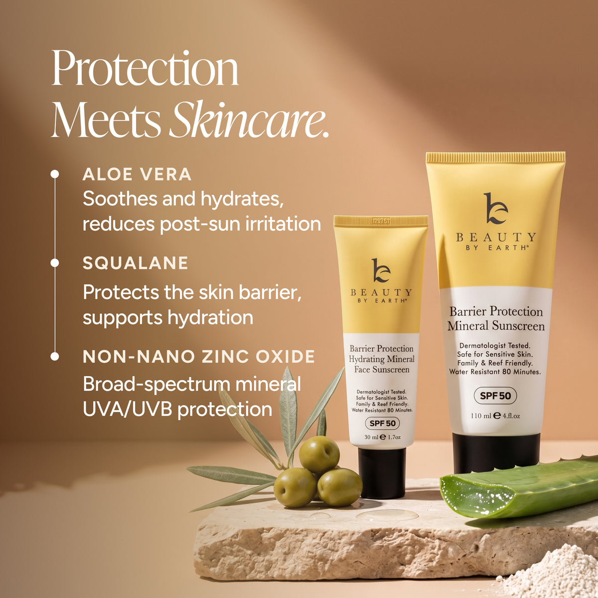 Beauty by Earth Barrier Protection Mineral Sunscreen shown in a yellow squeeze tube alongside a smaller matching face sunscreen tube, styled on a stone slab with olives, aloe vera leaves, and powder against a warm beige background with product feature text.