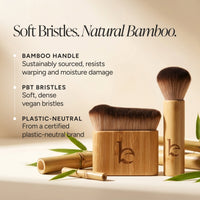 Two bamboo brushes displayed on a warm beige background with text highlighting sustainable bamboo handles, soft PBT bristles, and plastic-neutral certification. Bamboo pieces and green leaves are scattered around.