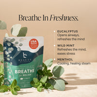 Beauty by Earth Breathe shower steam packet in eucalyptus mint, styled with fresh eucalyptus and mint leaves on a warm beige background with descriptive text.