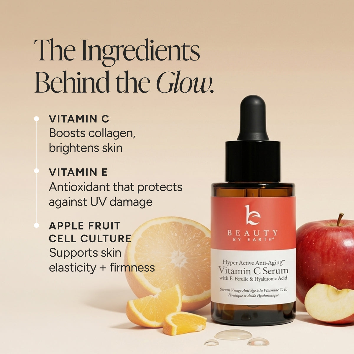 Beauty by Earth Vitamin C Serum in an amber glass dropper bottle with a coral-pink label, shown beside sliced orange, apple pieces, and text highlighting key ingredients on a warm beige background.