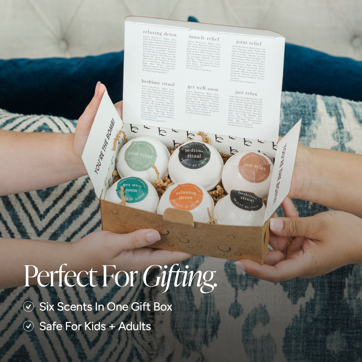 A gift box held by two hands, containing six scented bath bombs in a kraft paper box with a white insert. The text overlay at the bottom reads 'Perfect For Gifting.