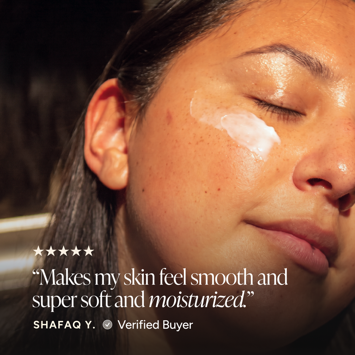 Close-up of a woman's face with a white cream product applied to her cheek, accompanied by a five-star review quote from Shafq Y. Verified Buyer.