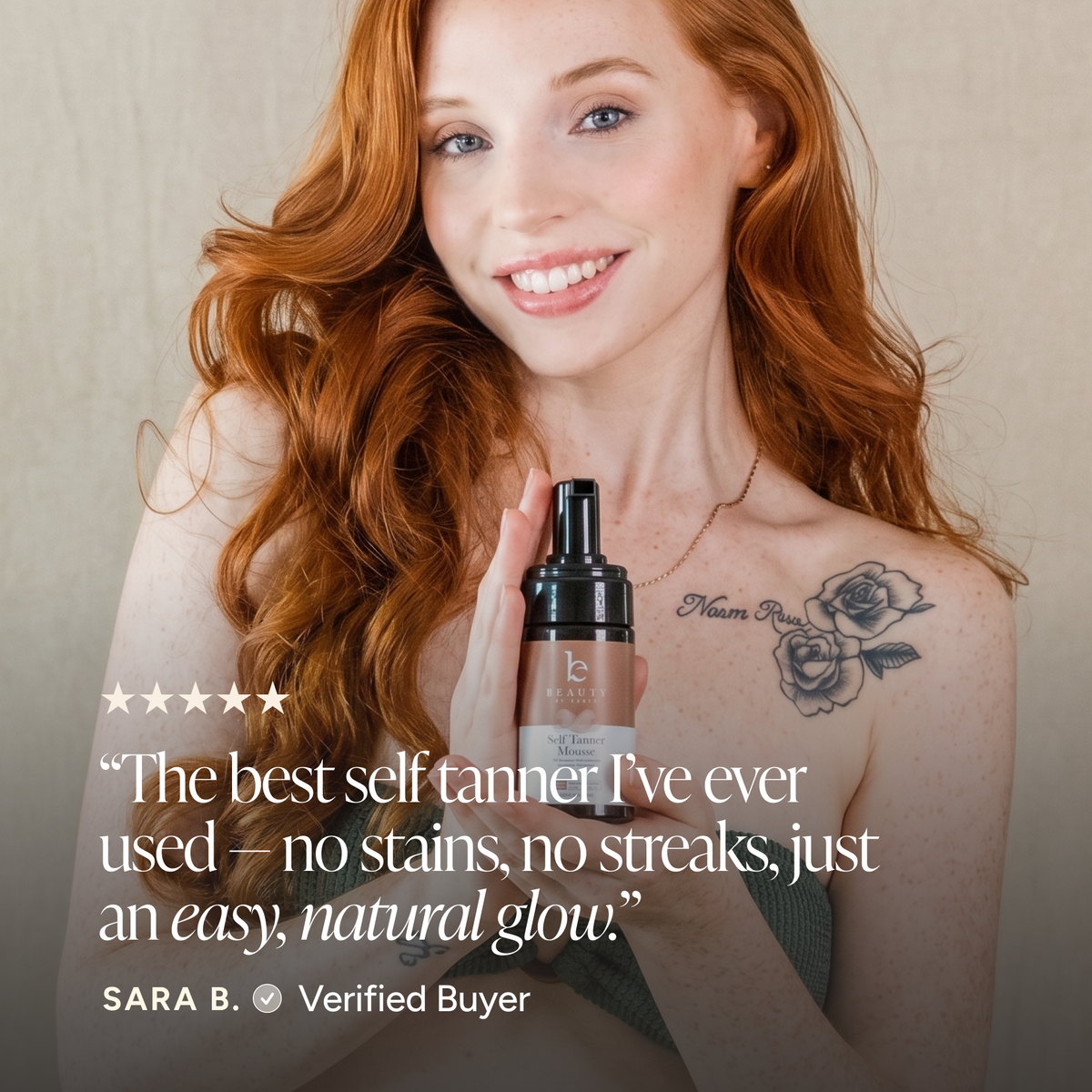 A smiling woman with long red hair holds a bottle of self-tanner against a soft beige background. A review quote from 'Sara B.