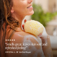 A woman in a shower holds a yellow sponge, with white foam on her shoulder and a quote overlay on the left.
