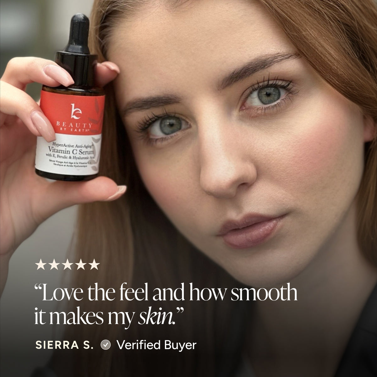 A close-up beauty ad showing a woman holding a small dropper bottle labeled Beauty by Earth Vitamin C Serum. The image includes a five-star quote and the text 'SIERRA S.