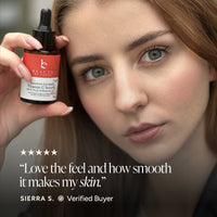 A close-up beauty ad showing a woman holding a small dropper bottle labeled Beauty by Earth Vitamin C Serum. The image includes a five-star quote and the text 'SIERRA S.