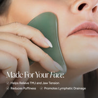 A close-up of a person using a green jade Gua sha facial scraping tool on their cheek, with text overlays that read 'Made For Your Face' and bullet points about relieving TMJ and jaw tension, reducing puffiness, and promoting lymphatic drainage.