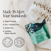 A pouch of Beauty by Earth Breathe for Relief sugar-free mint nicotine gum tablets is displayed on a soft white textured blanket with decorative eucalyptus leaves and white sugar cubes. Text on the left highlights product benefits: vegan formula, dye and paraben free, sulfate free, and certified plastic-neutral.