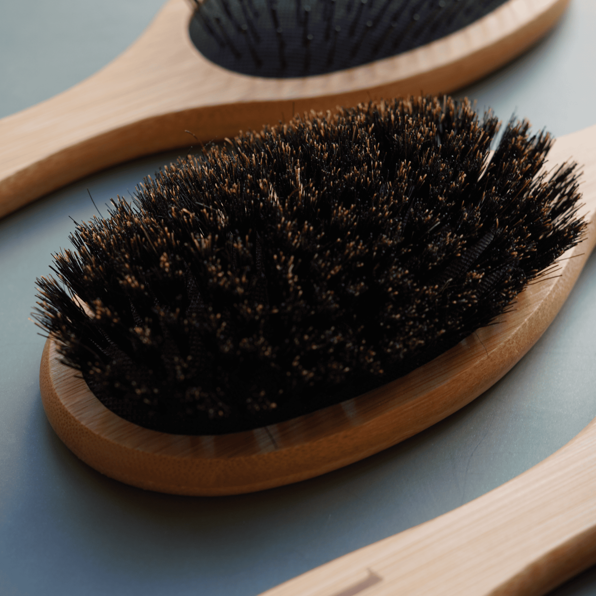 Wooden brush with bristles on a blue surface