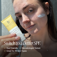 A woman outdoors holds a tube of Barrier Protection Mineral Sunscreen while applying white sunscreen cream to her cheek. The image features promotional text at the bottom: 'Switch to a Better SPF.