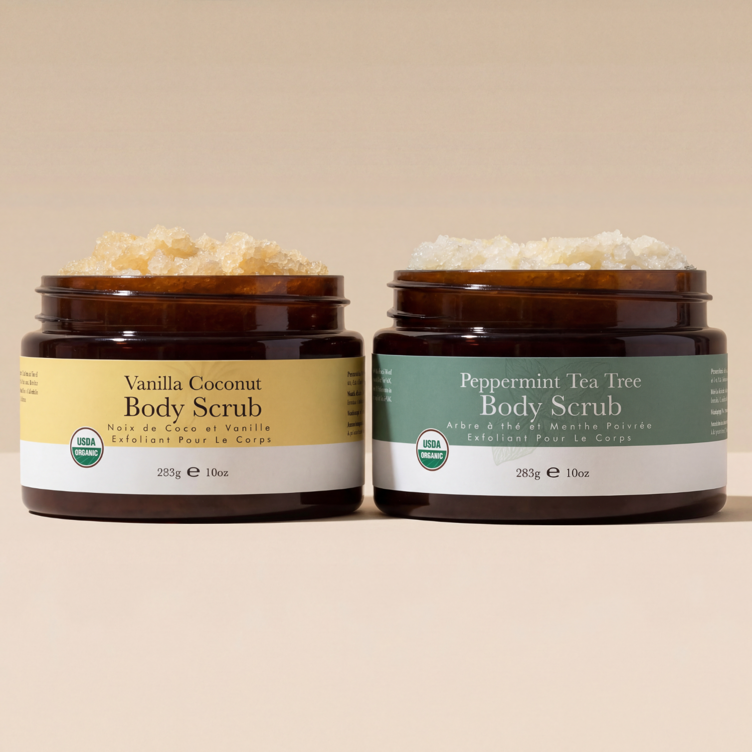 Two jars of Vanilla Coconut and Peppermint Tea Tree body scrubs on a beige background