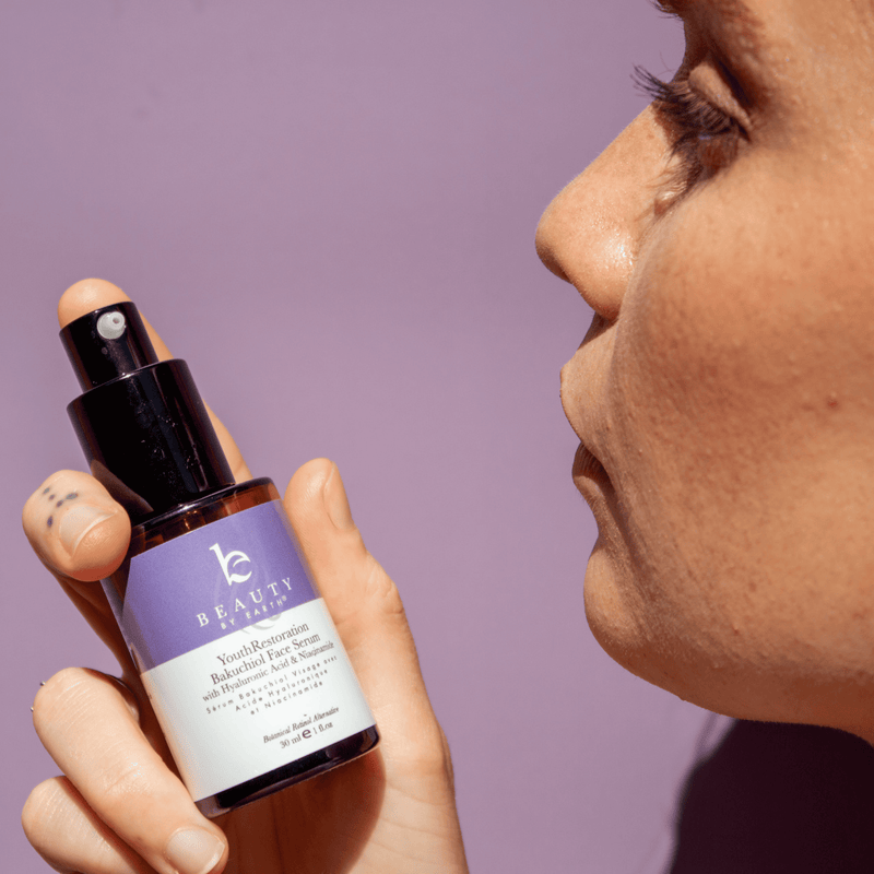 Person holding a bottle of 'Beauty' serum with a blurred background