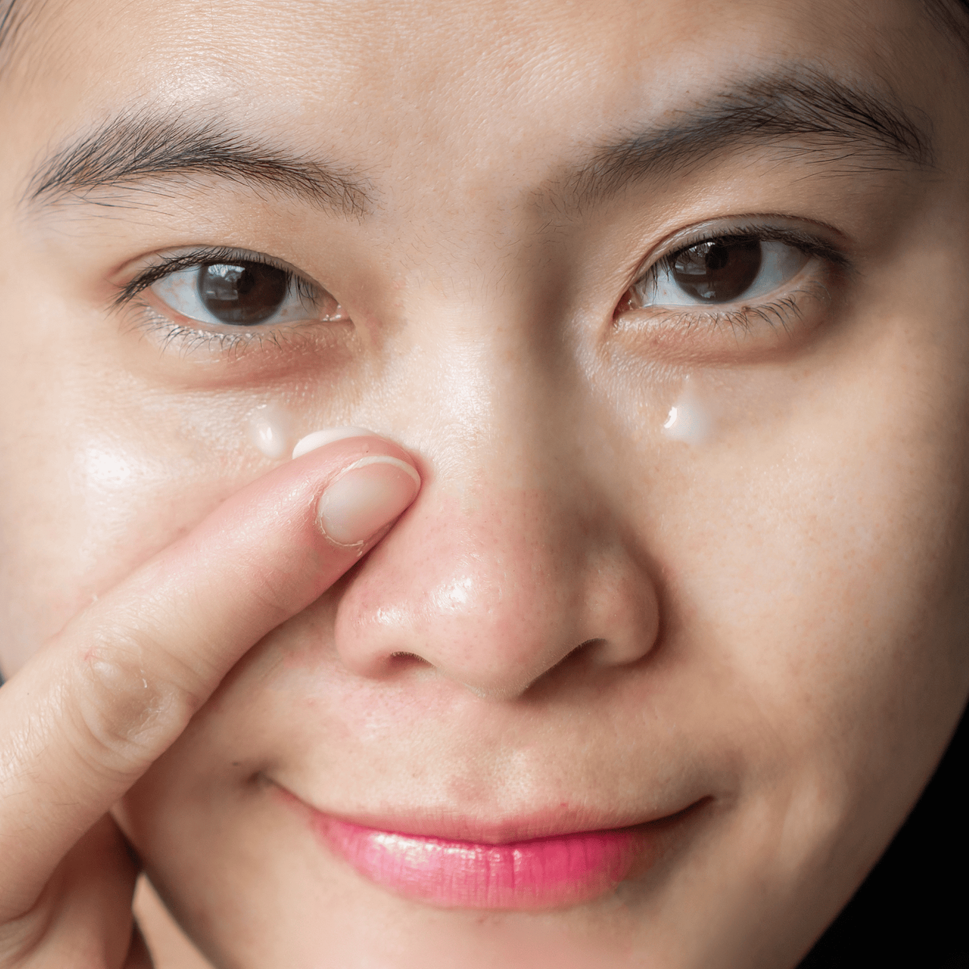 Close-up of a person applying cream to their face