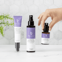 Three skincare products with purple labels on a white surface.