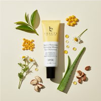 Tube of Beauty by Earth sunscreen surrounded by natural ingredient elements on a light background