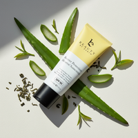 Sunscreen tube with aloe vera leaves on a light background