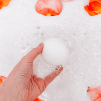 Bath bomb being used in the bathtub with flowers
