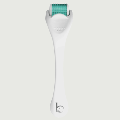 White derma roller with green head on a light gray background