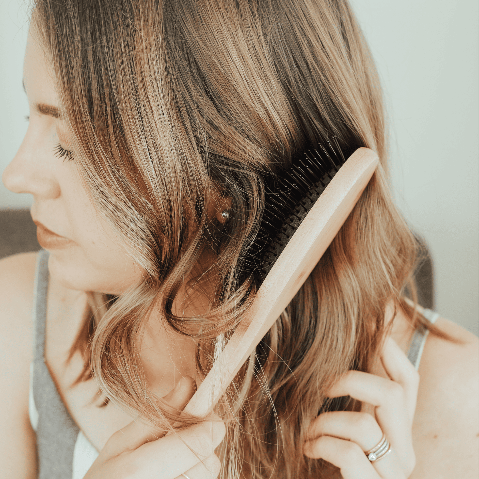 Woman brushing her hair with a wooden comb