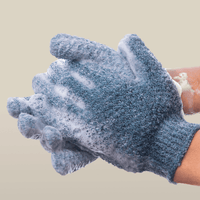 Heavy exfoliating gloves with soap suds on a beige background