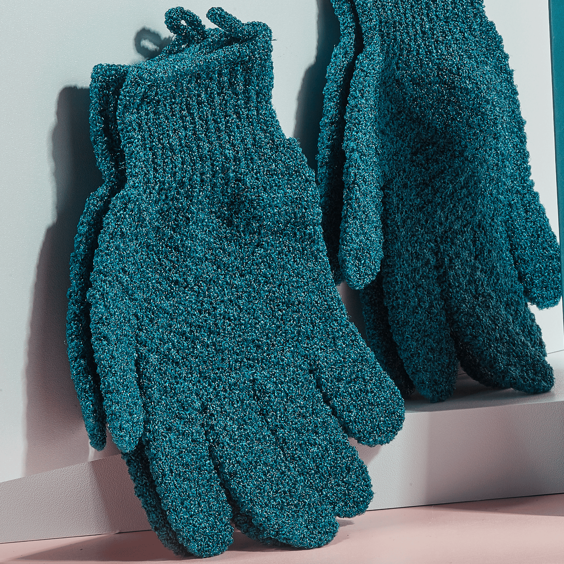 Pair of exfoliating gloves on a light background