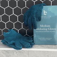 Medium exfoliating gloves with packaging on a tiled surface