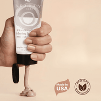 Hand squeezing clay face mask on surface - made in USA with natural ingredients.