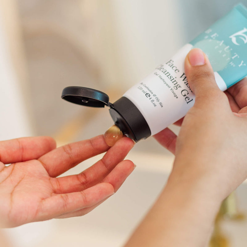 Person holding a bottle of cleansing gel with a blurred background