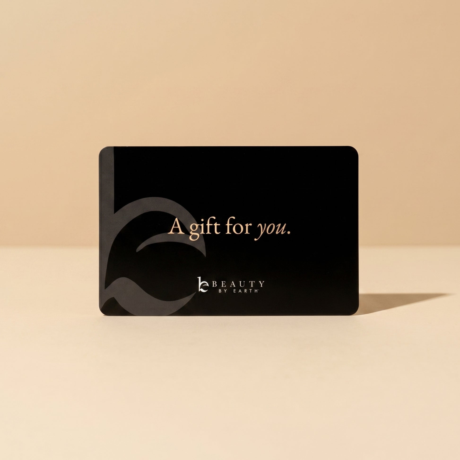 Black gift card with 'A gift for you.' text on a beige background