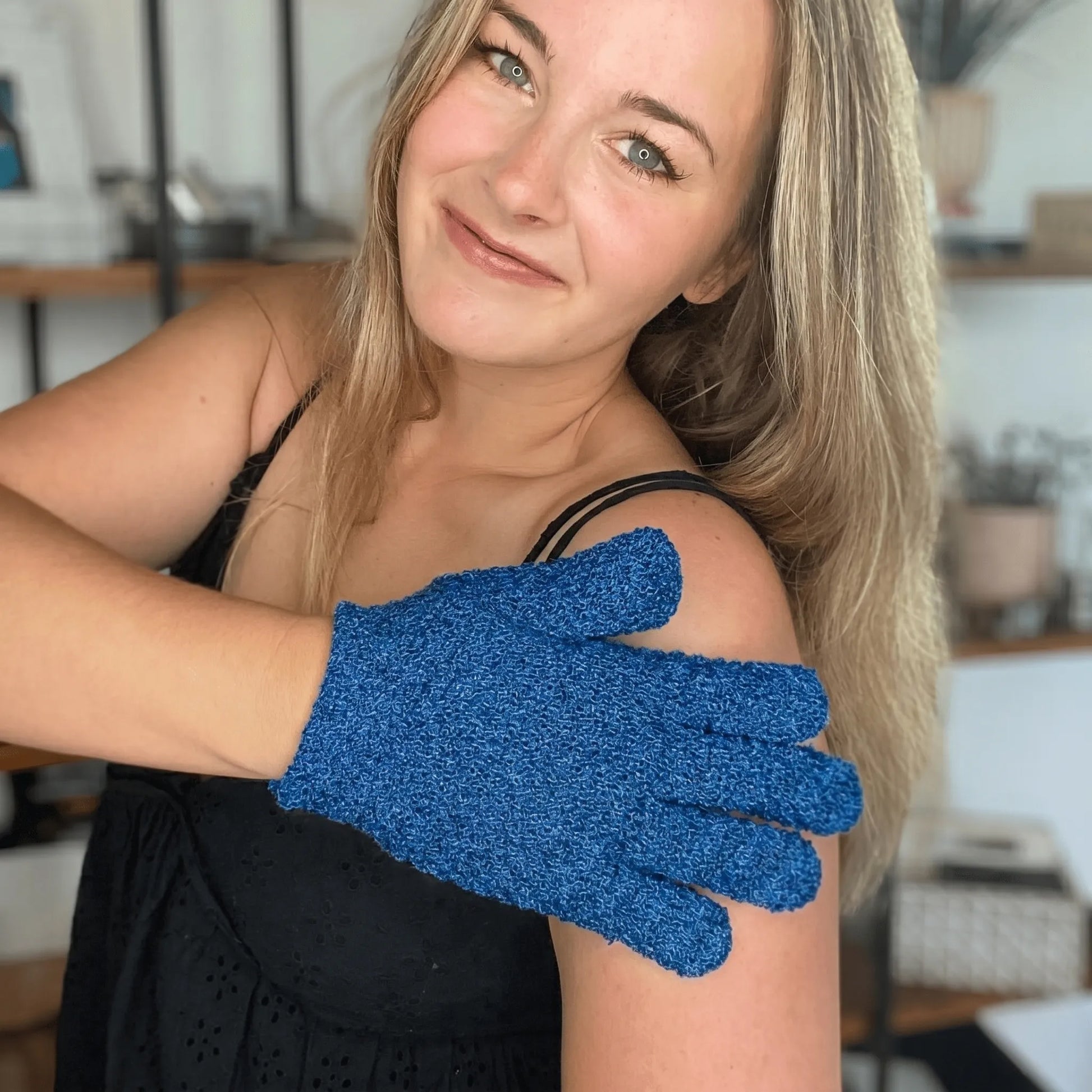 Woman wearing a blue exfoliating glove on her arm