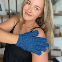 Woman wearing a blue exfoliating glove on her arm