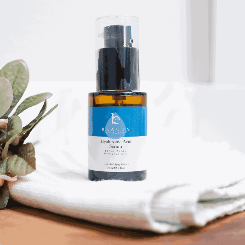 Hydroquinone Acid Serum bottle on a white surface with a plant in the background