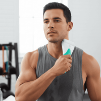 Man holding a white and green ice roller in a gym setting