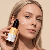 Woman applying Invisible matte barrier defense ceramide sunscreen serum TO her face with a beige background - Invisible Matte Barrier Defense Ceramide Sunscreen Serum  
