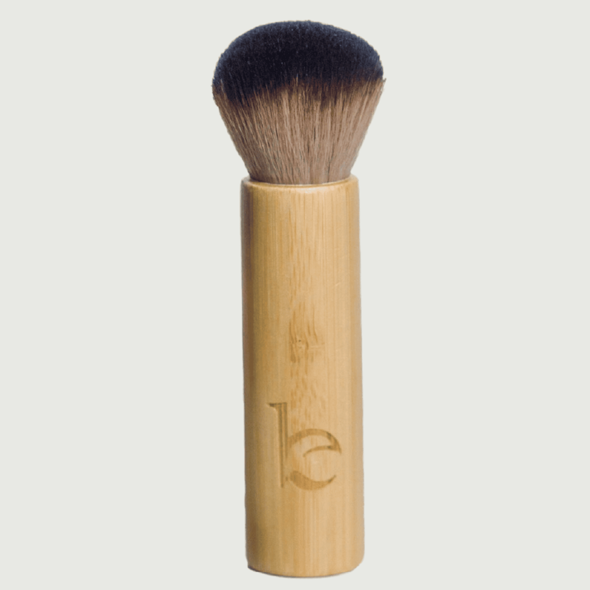 Bamboo makeup brush with black bristles on a light gray background