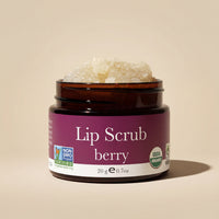 Jar of berry lip scrub with visible brand logos on a beige background