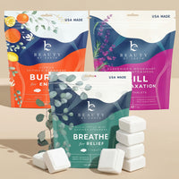 Packaging of 'Beauty by Earth' shower steamers and tablets on a beige background